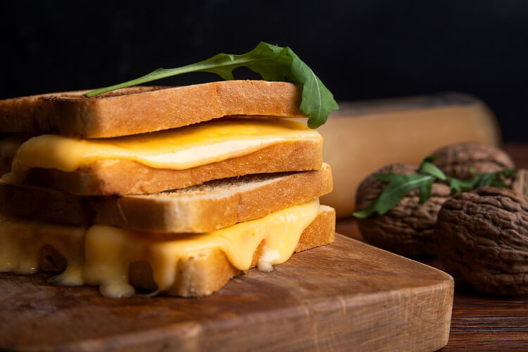 grilled cheese sandwich on wooden block on a table