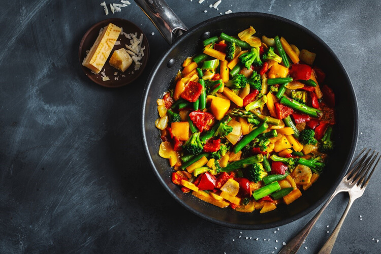 Vegetable stir fry in a black bowl