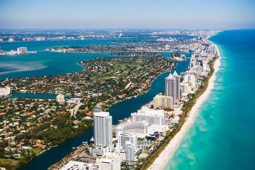 Aerial view of Miami Beach coastline with hotels, waterways, and the Atlantic Ocean