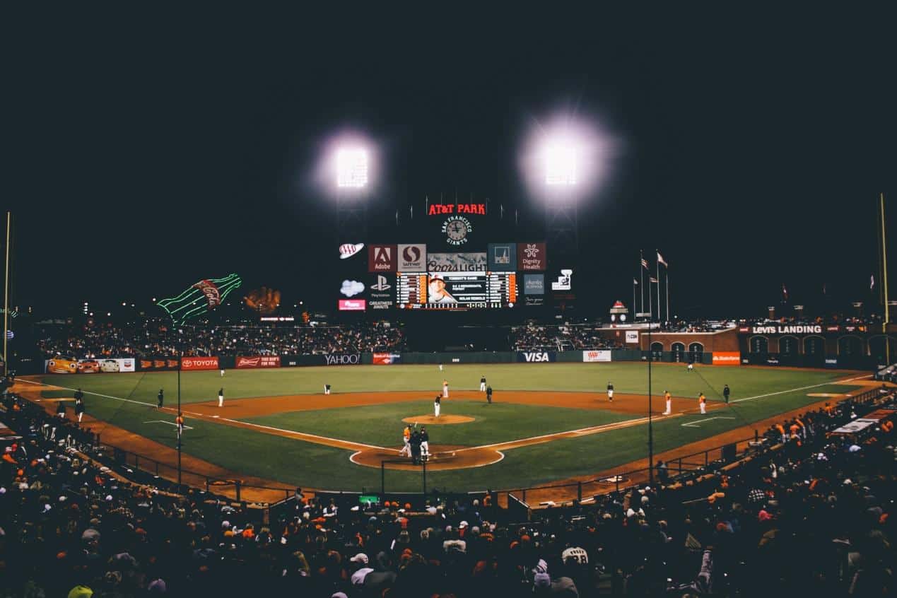 A sports field and stands for fans to sit on at night