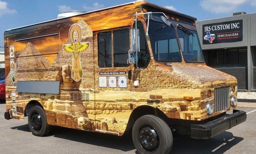 Giza food truck with a full photographic wrap depicting the Egyptian pyramids, the Sphinx, and an ankh logo against a golden desert sunset, parked outside JRS Custom Inc in Texas