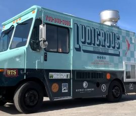 Passenger side of the completed Ludicrous food truck displaying the full branded wrap with large logo, tagline "The Food You Crave," rooftop exhaust vent, and sponsor decals