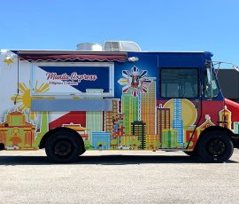 Manila Express Filipino Cuisine food truck with a vibrant full wrap featuring the Philippine flag colors, a colorful Manila cityscape illustration, sunburst graphic, and a chef mascot, with an open side awning over the service window