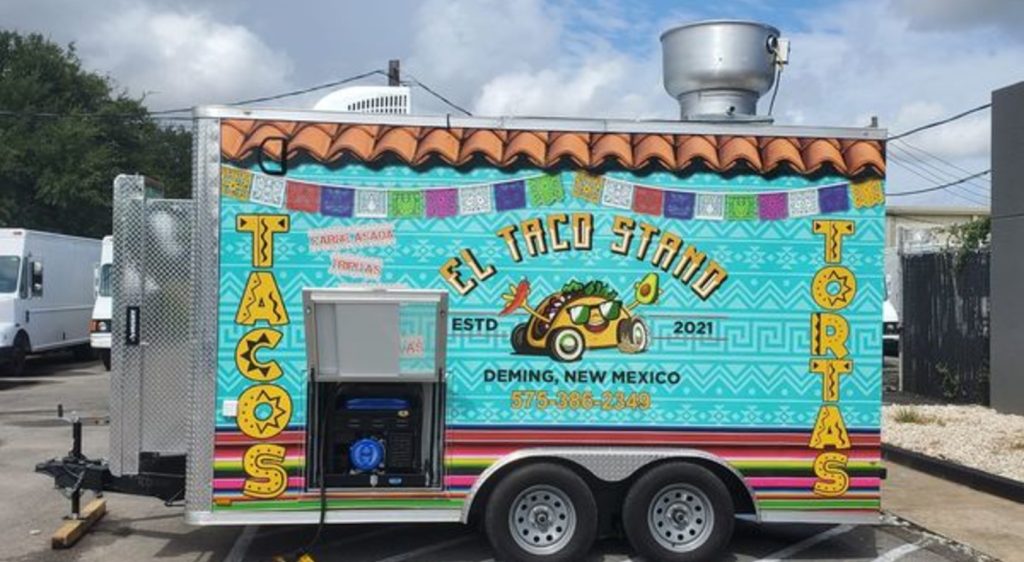 El Taco Stand food trailer with colorful Mexican-themed wrap graphics serving tacos and tortas from Deming New Mexico