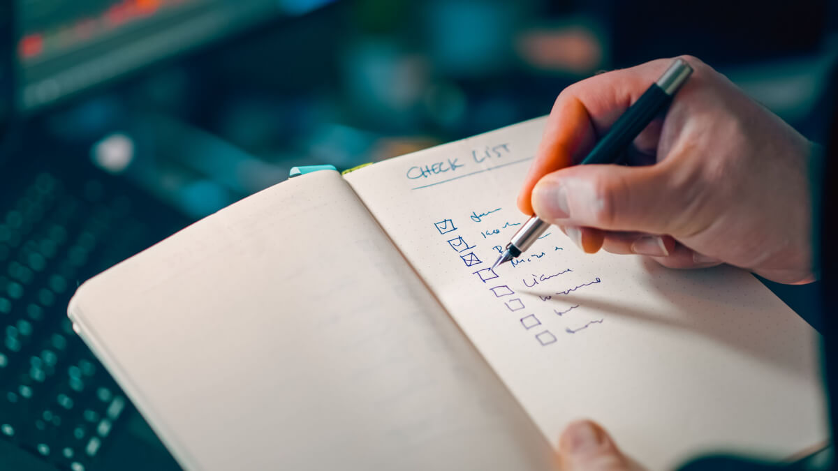 handing writing a food truck maintenance list with a pen into a notebook