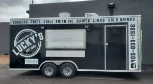 Lucky's Burger and Chili Co. food trailer with service window and full wrap graphics listing menu items