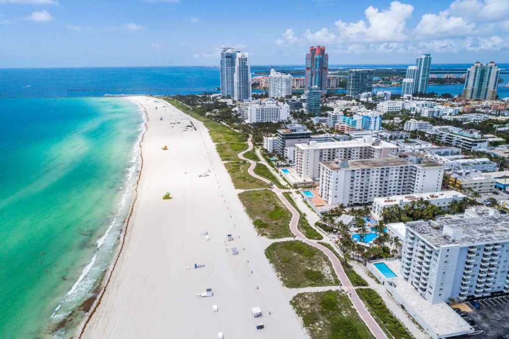 Aerial view of South Beach Miami with white sand beach, turquoise water, and oceanfront hotels