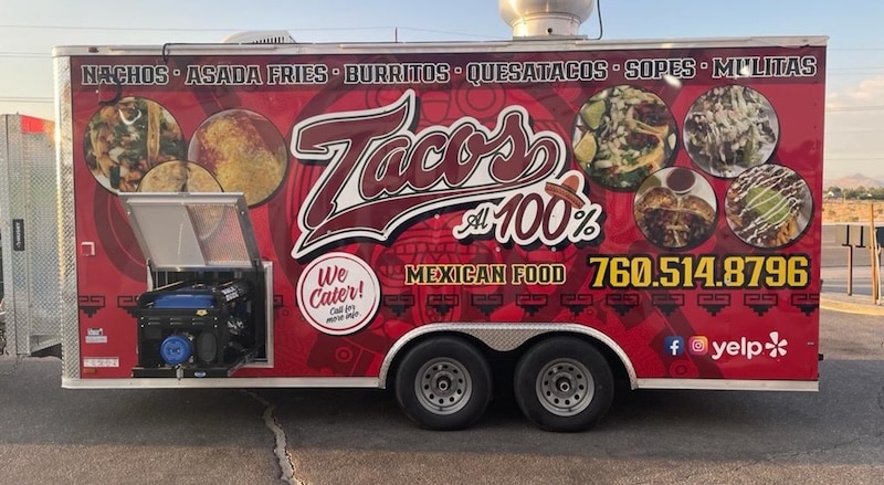 Tacos Al 100% Mexican food trailer with a bold red wrap featuring large food photography, menu items including nachos, burritos, and quesatacos, phone number, and social media icons, with an external generator mounted on the side