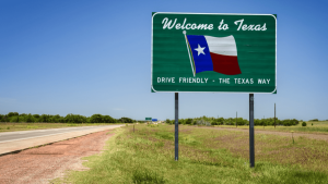 Welcome to Texas road sign along a highway with the Texas state flag and Drive Friendly slogan