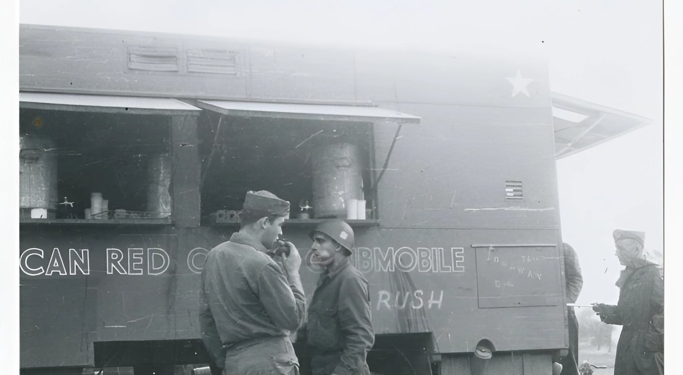 Vintage black and white photograph of soldiers gathered at an American Red Cross Clubmobile food truck during World War II